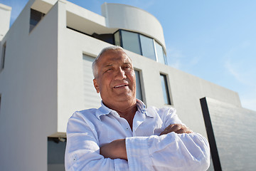 Image showing senior man in front of modern home