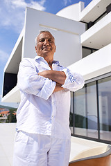 Image showing senior man in front of modern home