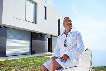 Image showing senior man in front of modern home