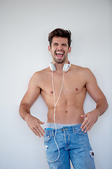 Image showing handsome young man listening music on headphones