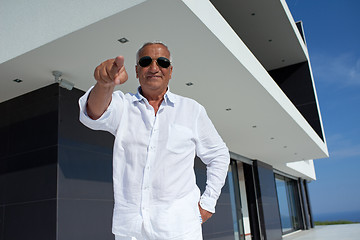 Image showing senior man in front of modern home