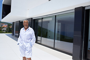 Image showing senior man in front of modern home