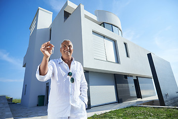 Image showing senior man in front of modern home