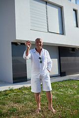 Image showing senior man in front of modern home