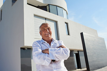 Image showing senior man in front of modern home