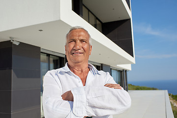 Image showing senior man in front of modern home