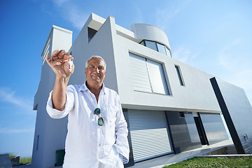 Image showing senior man in front of modern home