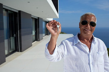 Image showing senior man in front of modern home