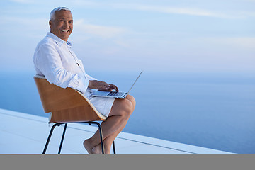 Image showing senior man working on laptop computer