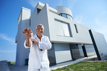 Image showing senior man in front of modern home