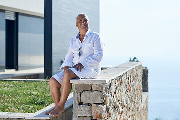 Image showing senior man in front of modern home