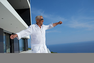 Image showing senior man in front of modern home