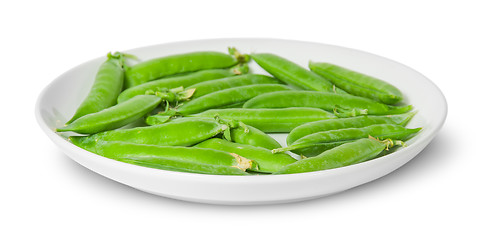 Image showing In front several pods of peas on a white plate