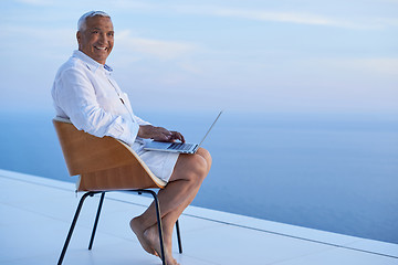 Image showing senior man working on laptop computer