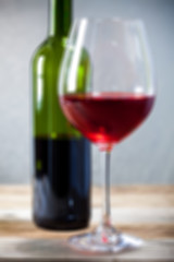 Image showing red wine in goblet and green bottle