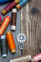 Image showing vintage buttons and old reels of varicolored thread on the text