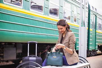 Image showing beautiful woman rummages in a bag