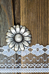 Image showing vintage button and lace tape on old wooden surface