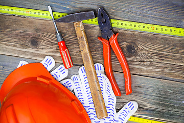 Image showing Vintage pliers, hammer, screwdriver, tape measure, a bright helm