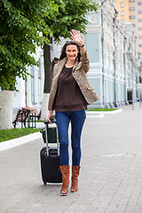 Image showing adult beautiful businesswoman with a suitcase walking along the 