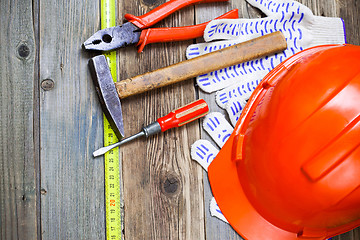 Image showing Vintage hammer, pliers, screwdriver, tape measure, a bright helm