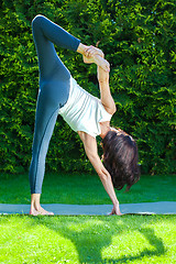 Image showing beautiful woman doing yoga on a green grass