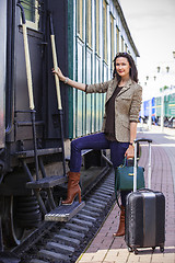 Image showing adult woman with a suitcase near the railway wagon