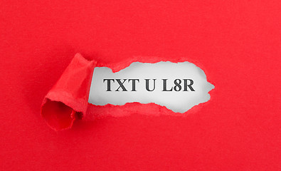 Image showing Text appearing behind torn red envelop