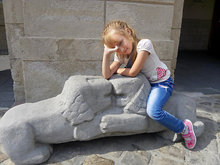 Image showing Little girl sitting on the lions sculpture