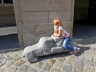 Image showing Small girl sitting on the lions sculpture