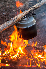 Image showing Water heating in camping kettle on fire