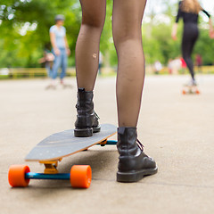 Image showing Girl practicing urban long board riding.