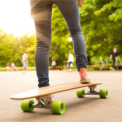 Image showing Girl practicing urban long board riding.