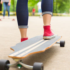 Image showing Girl practicing urban long board riding.