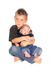 Image showing Little boy holding his three weeks old brother.