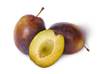 Image showing Two violet plums and half stand