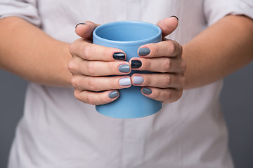 Image showing Female hands with blue cup