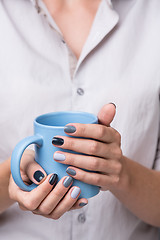 Image showing Female hands with blue cup