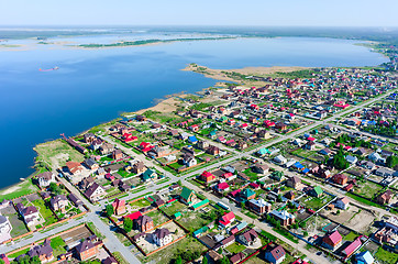 Image showing Beautiful small green village near lake from above