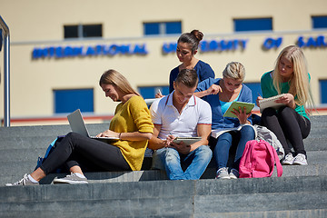 Image showing students outside sitting on steps