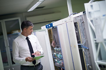 Image showing network engineer working in  server room