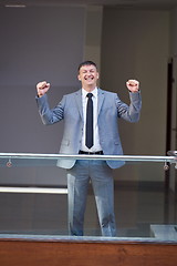 Image showing happy business man raise hands from joy