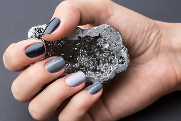 Image showing Female hand with textured silver mineral