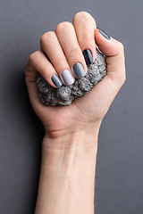 Image showing Female hand with textured silver mineral