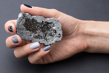 Image showing Female hand with textured silver mineral