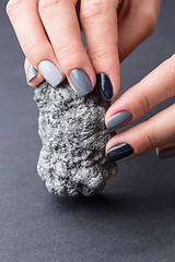 Image showing Female hands with textured silver mineral