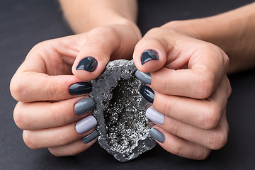 Image showing Female hands with textured silver mineral