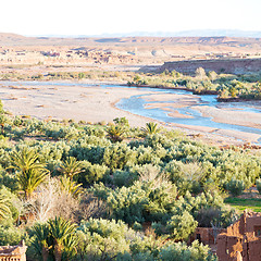 Image showing sunset in africa old construction near       the river blue