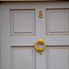 Image showing handle in london antique brown door  rusty  brass nail and light