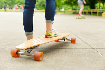 Image showing Teenage girl practicing riding long board.